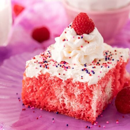 slice of raspberry jello poke cake on a purple plate