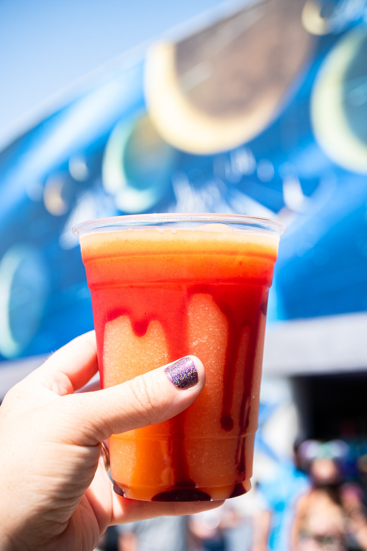 hand holding a blood orange slush at Disneyland