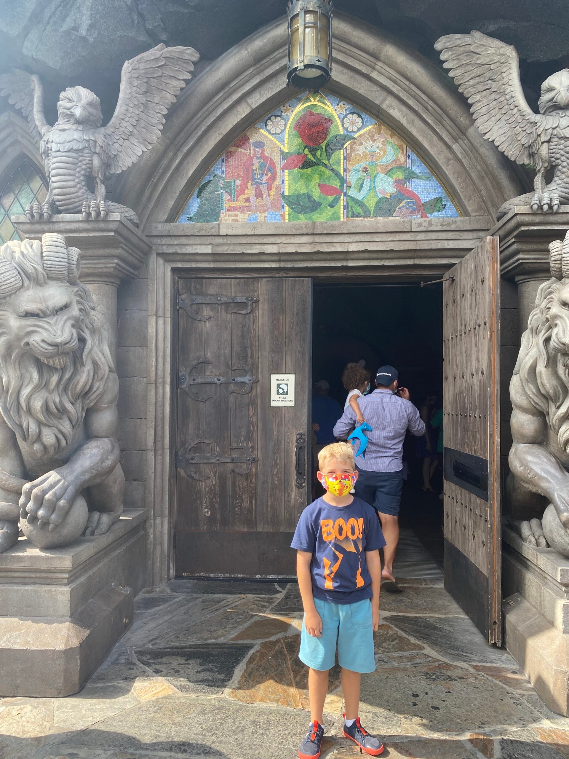boy standing in front of Be Our Guest
