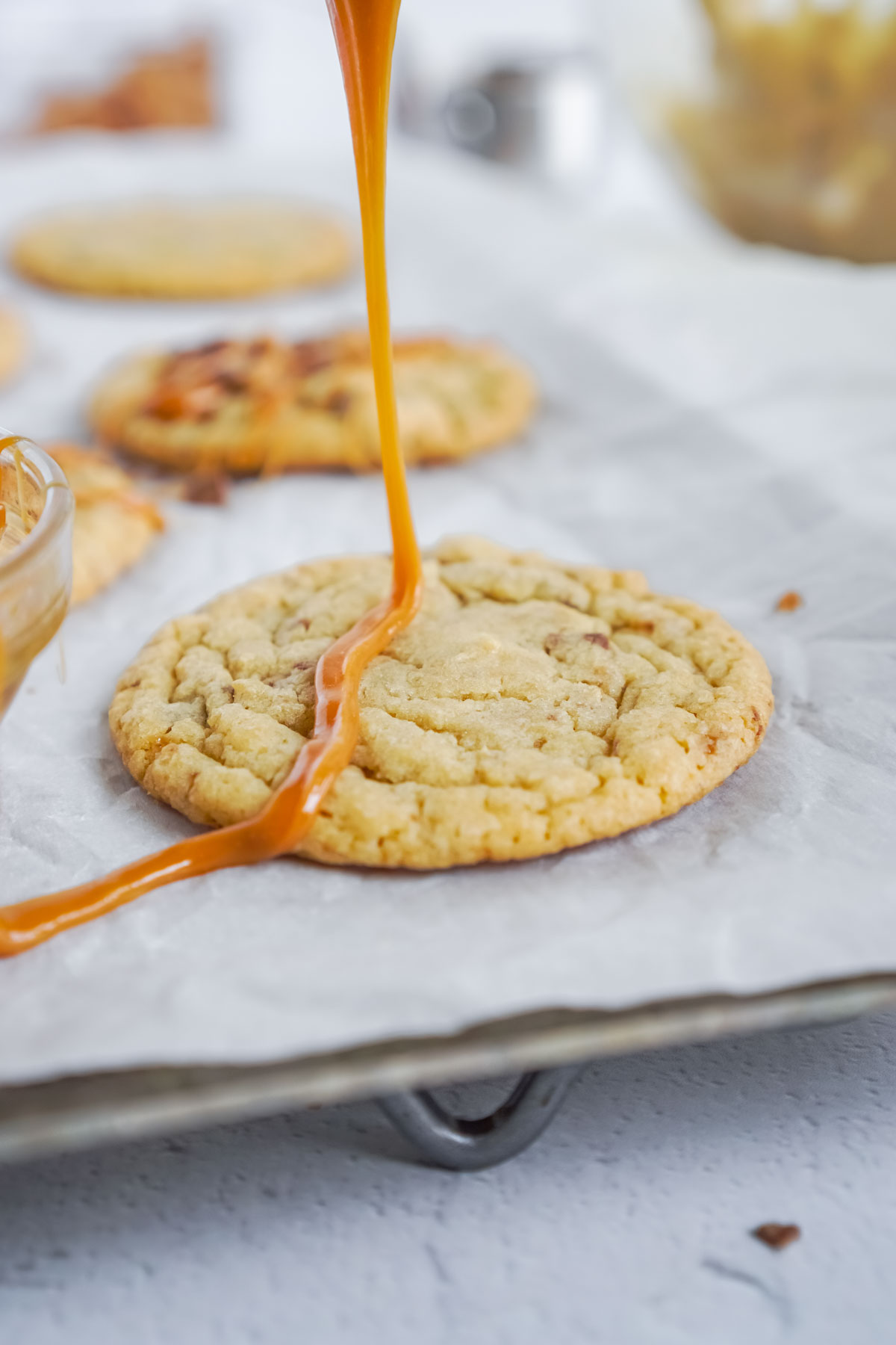 drizzling caramel over caramel toffee cookies