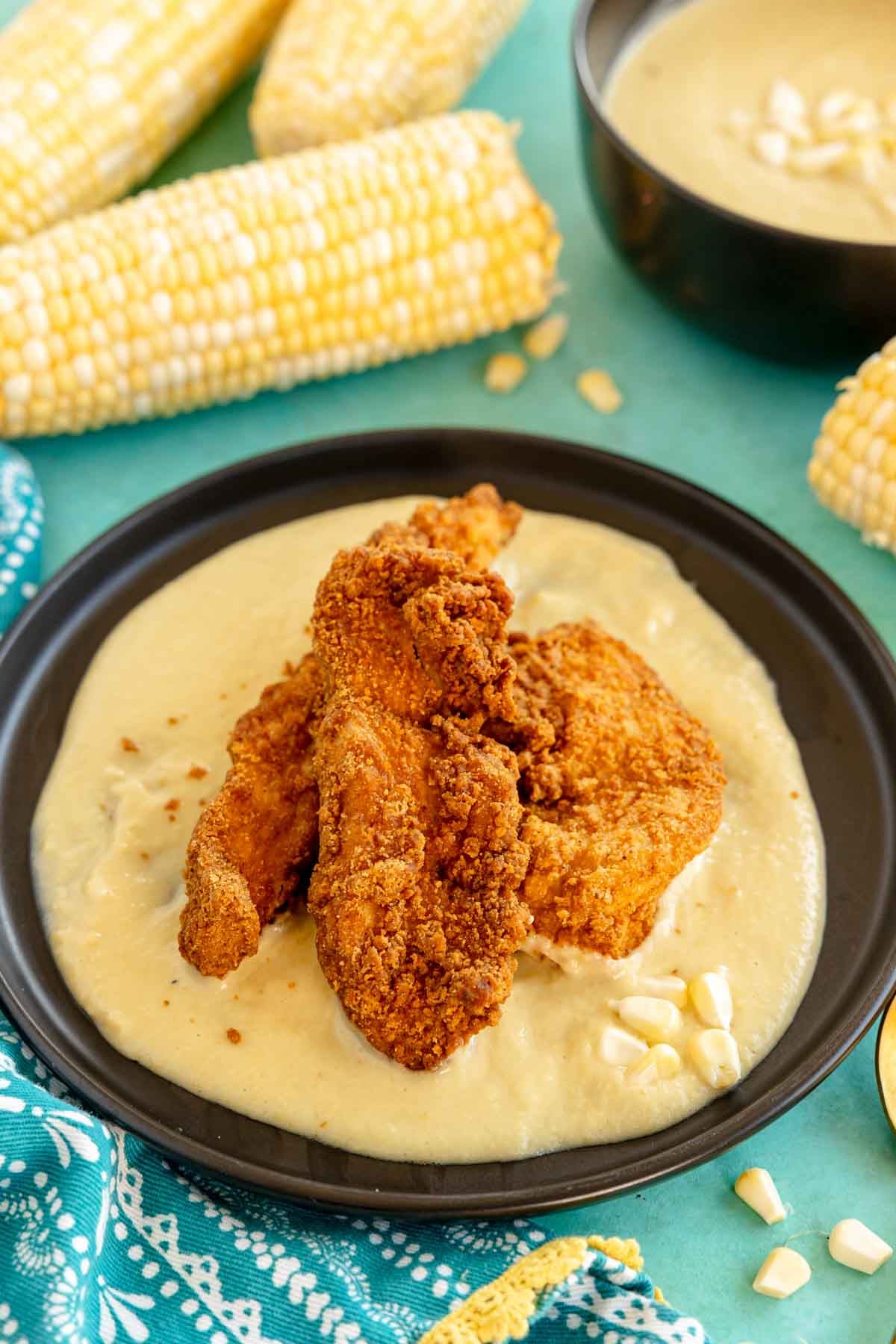 fried chicken on top of a corn puree