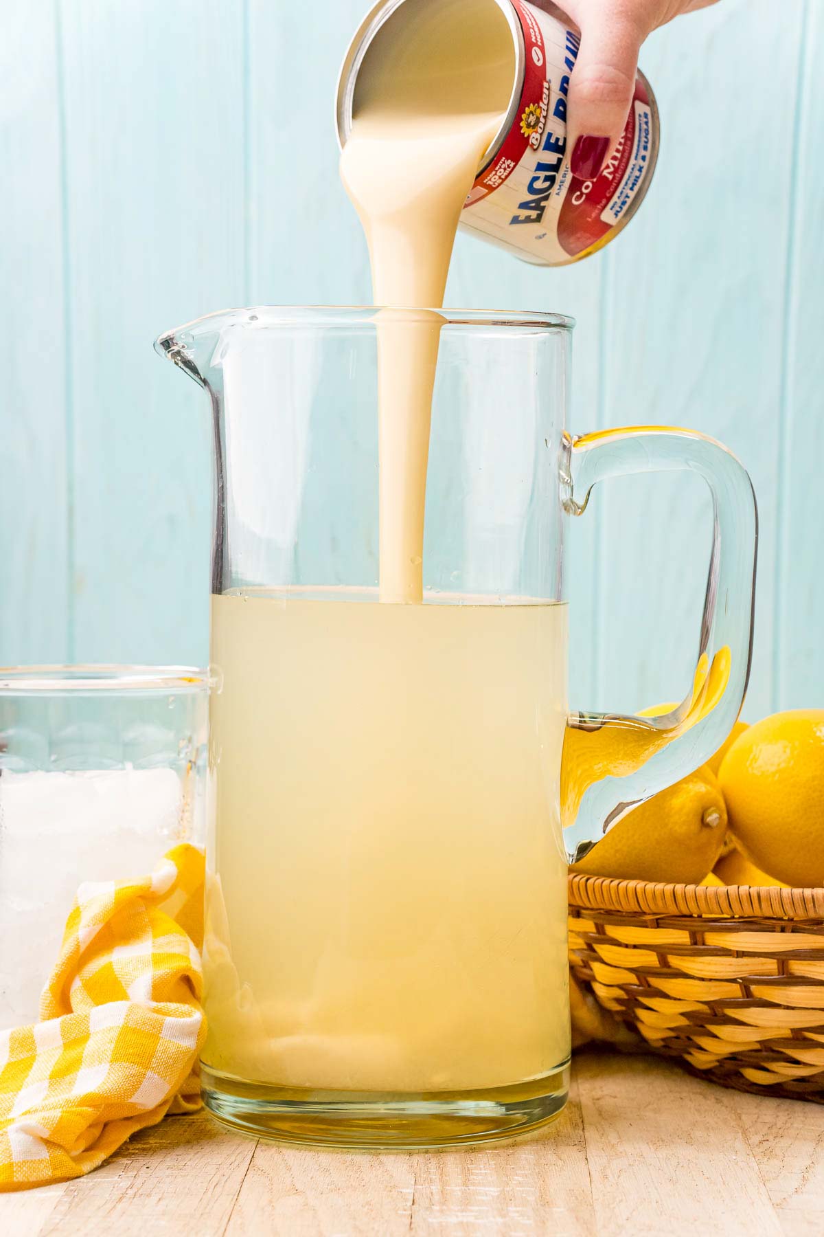 pouring sweetened condensed milk into a pitcher