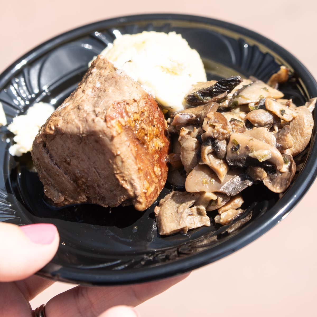 filet mignon and mashed potatoes on a black plate