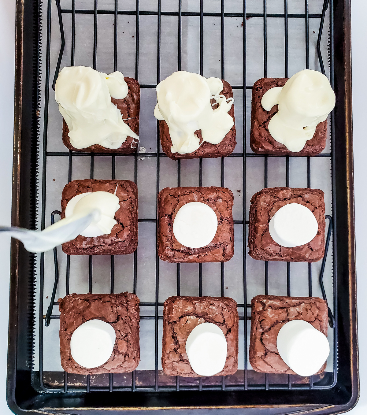 drizzling chocolate on top of ghost brownies