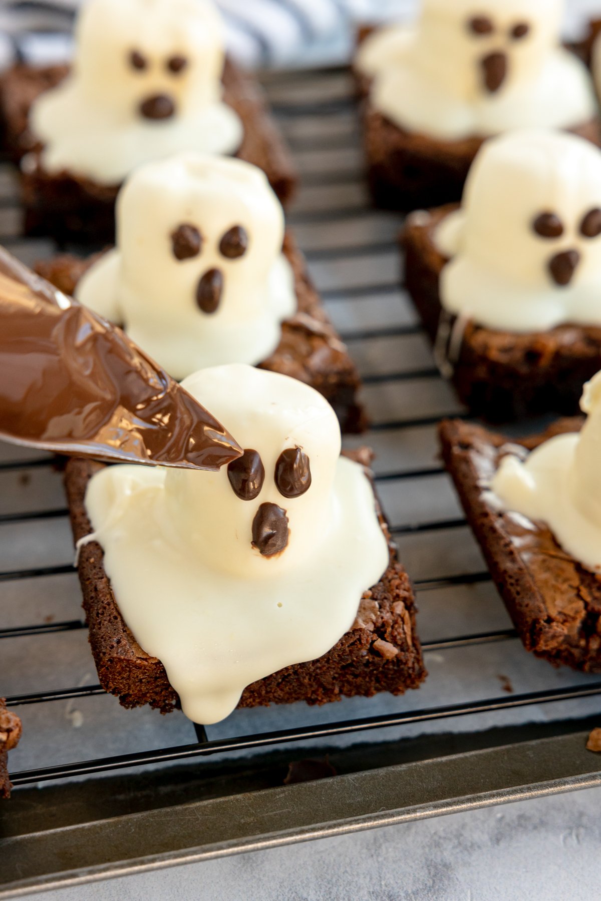 piping tip with chocolate adding a face to ghost brownies