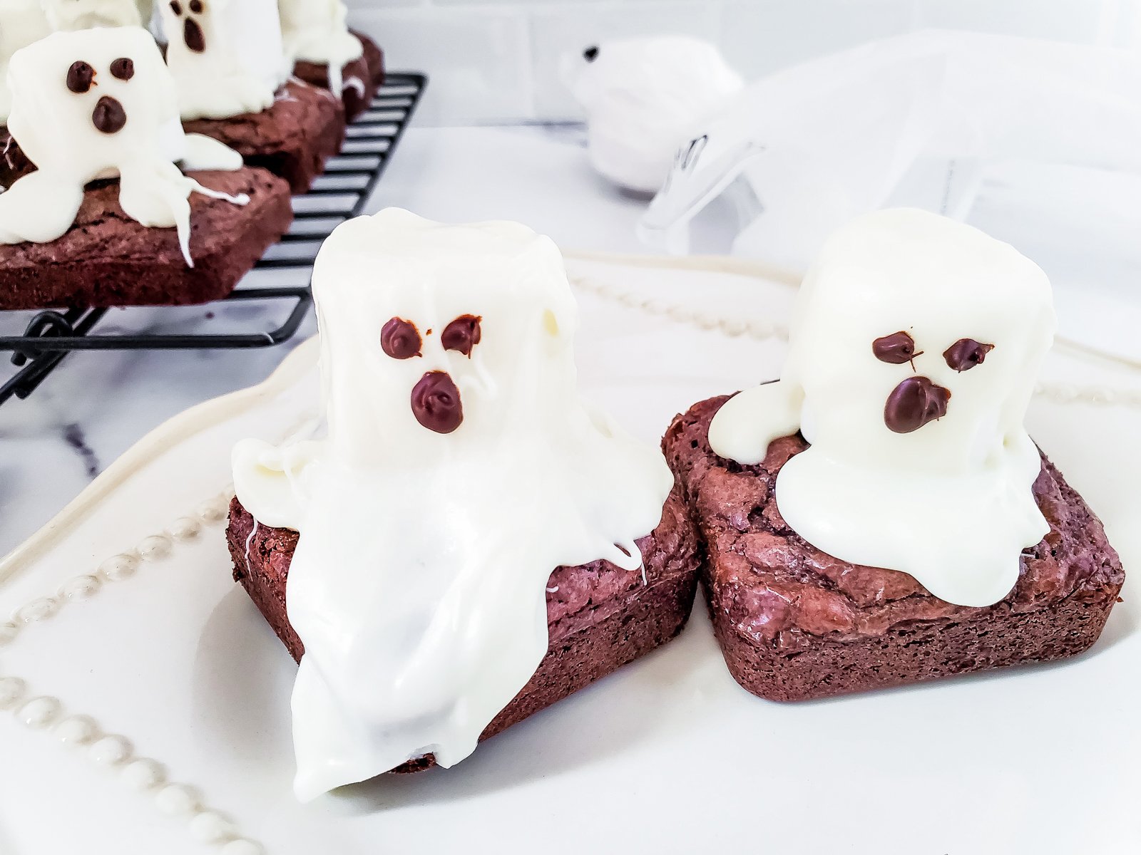 two cute ghost brownies on a white linen