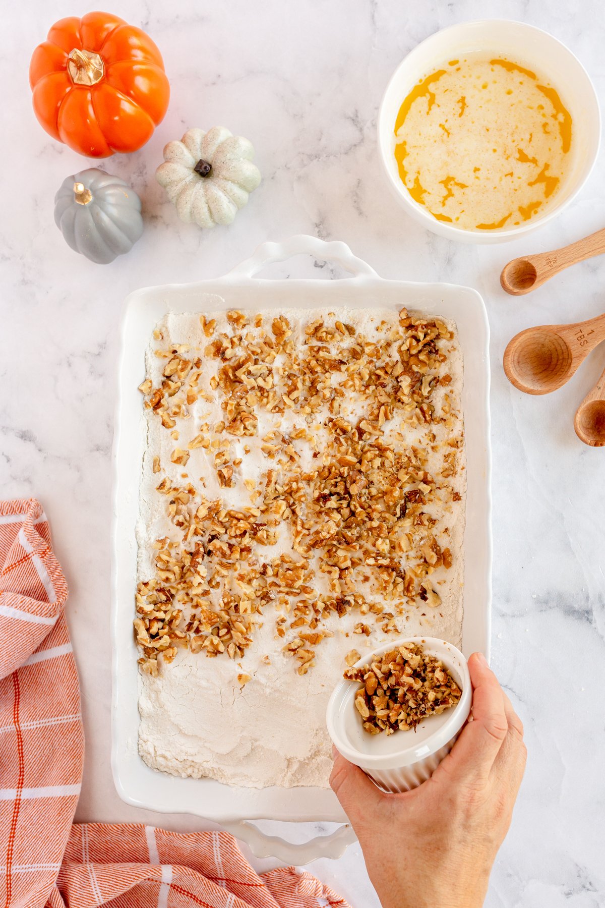 sprinkling walnuts on a cake