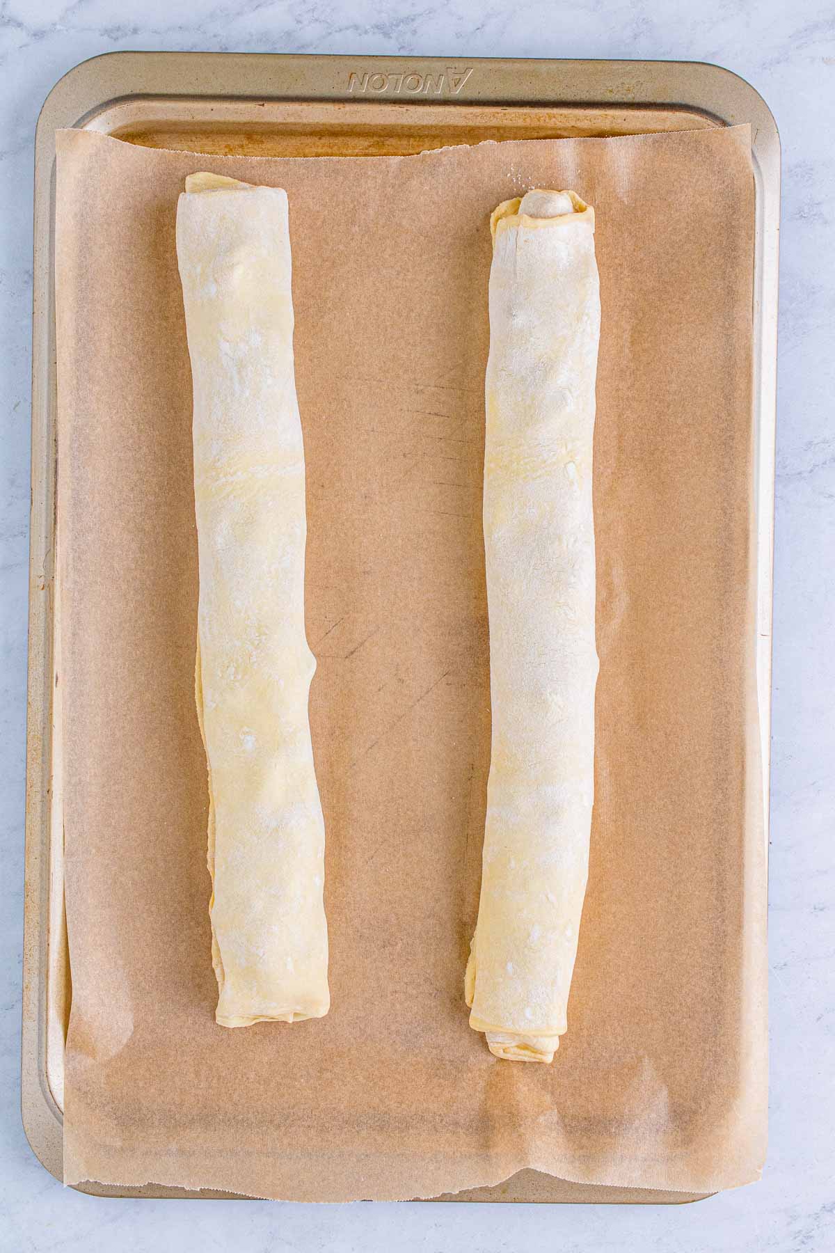 rolled up puff pastry on a baking sheet
