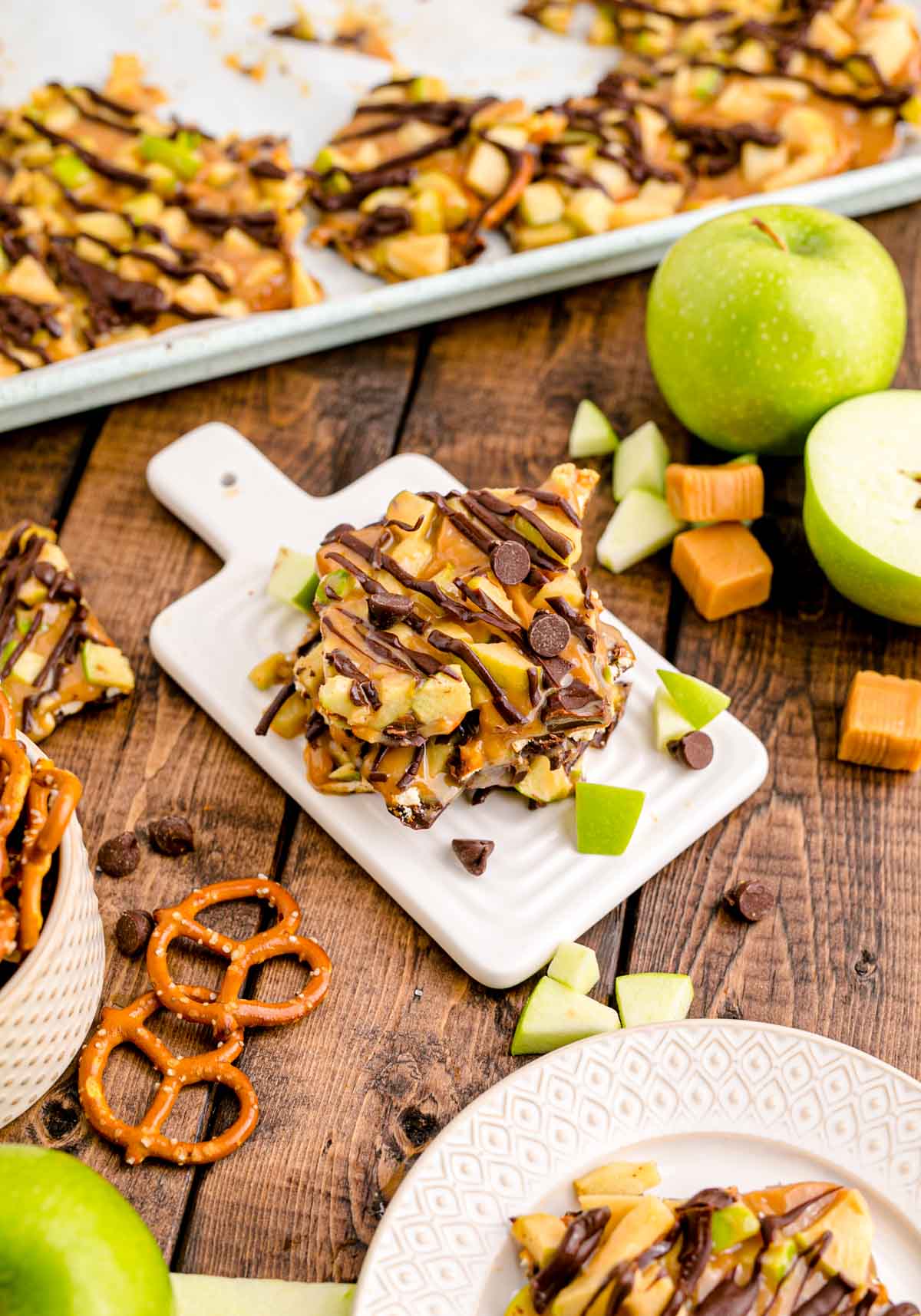 caramel apple bark stacked on a white plate