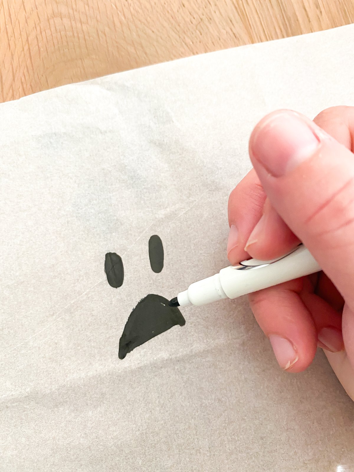 drawing a ghost face on a piece of tissue paper