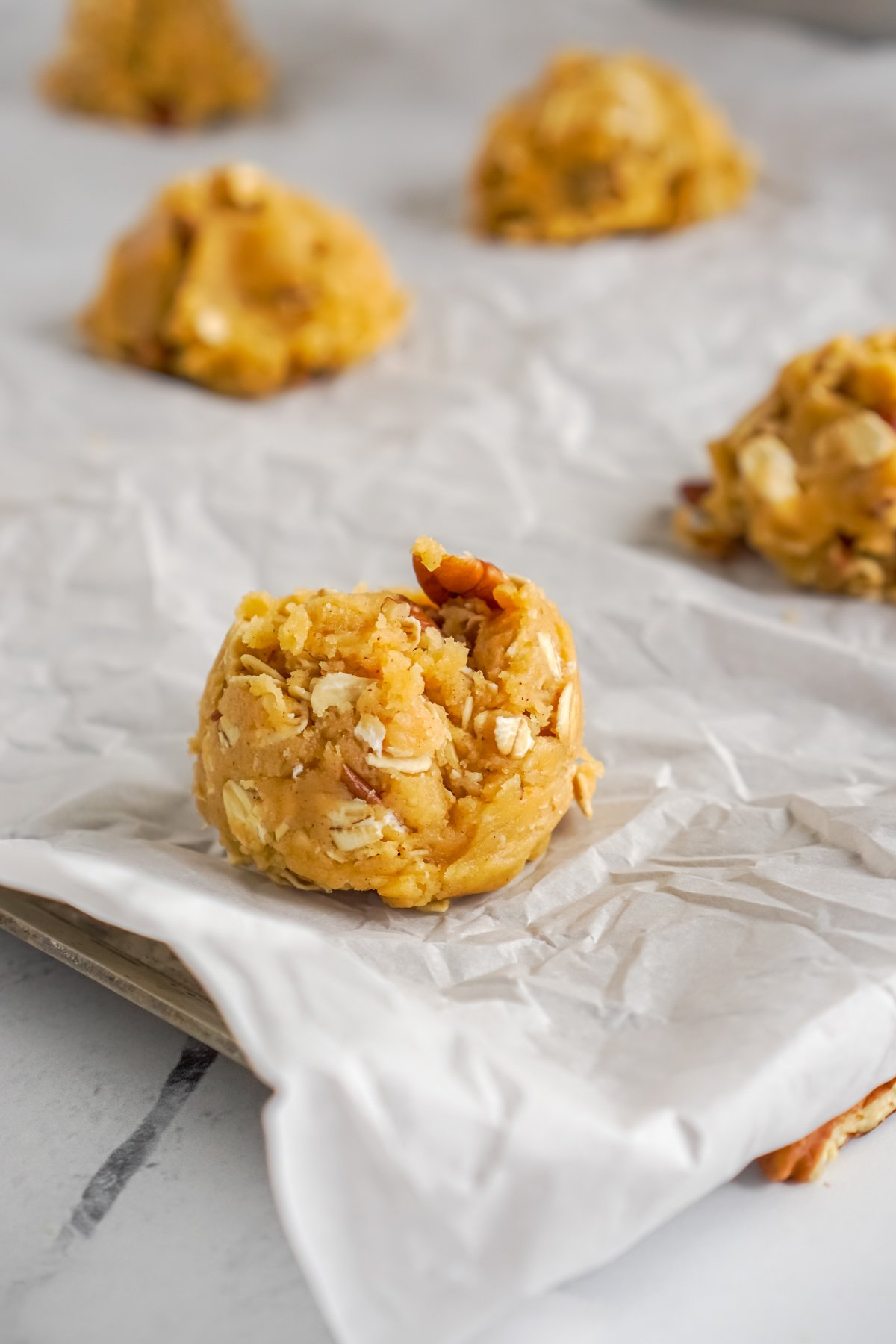 pumpkin oatmeal cookie dough ball on parchment paper