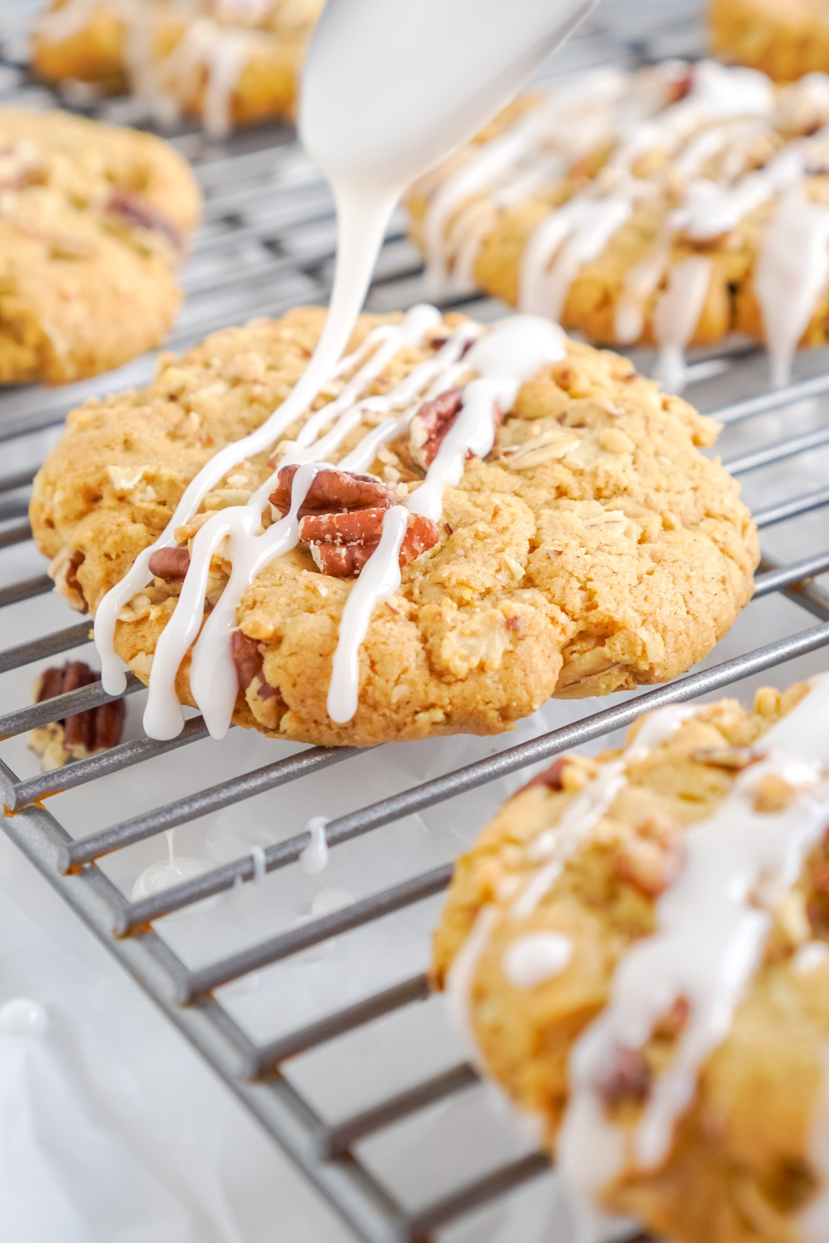 pouring glaze onto pumpkin oatmeal cookies