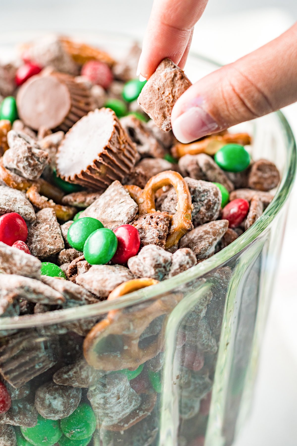 hand grabbing reindeer chow from a bowl