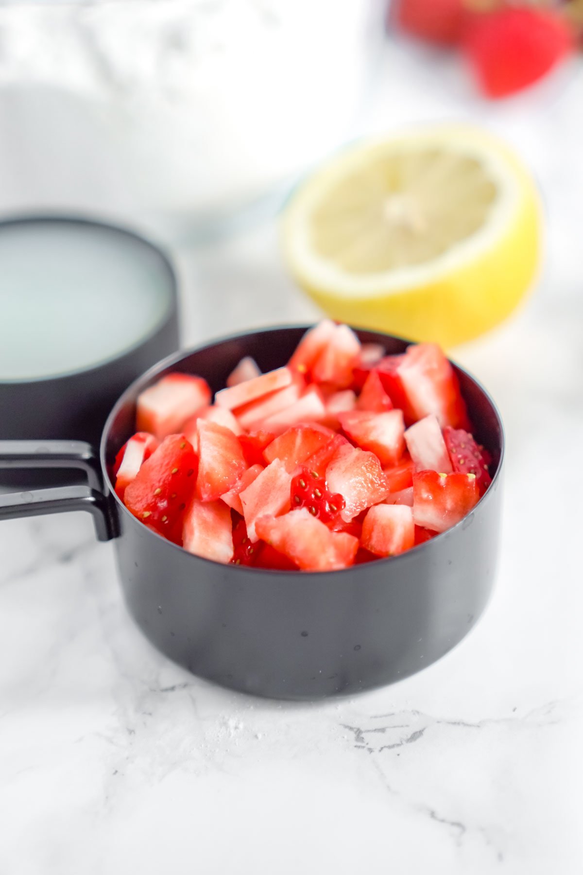 measuring cup with diced strawberries