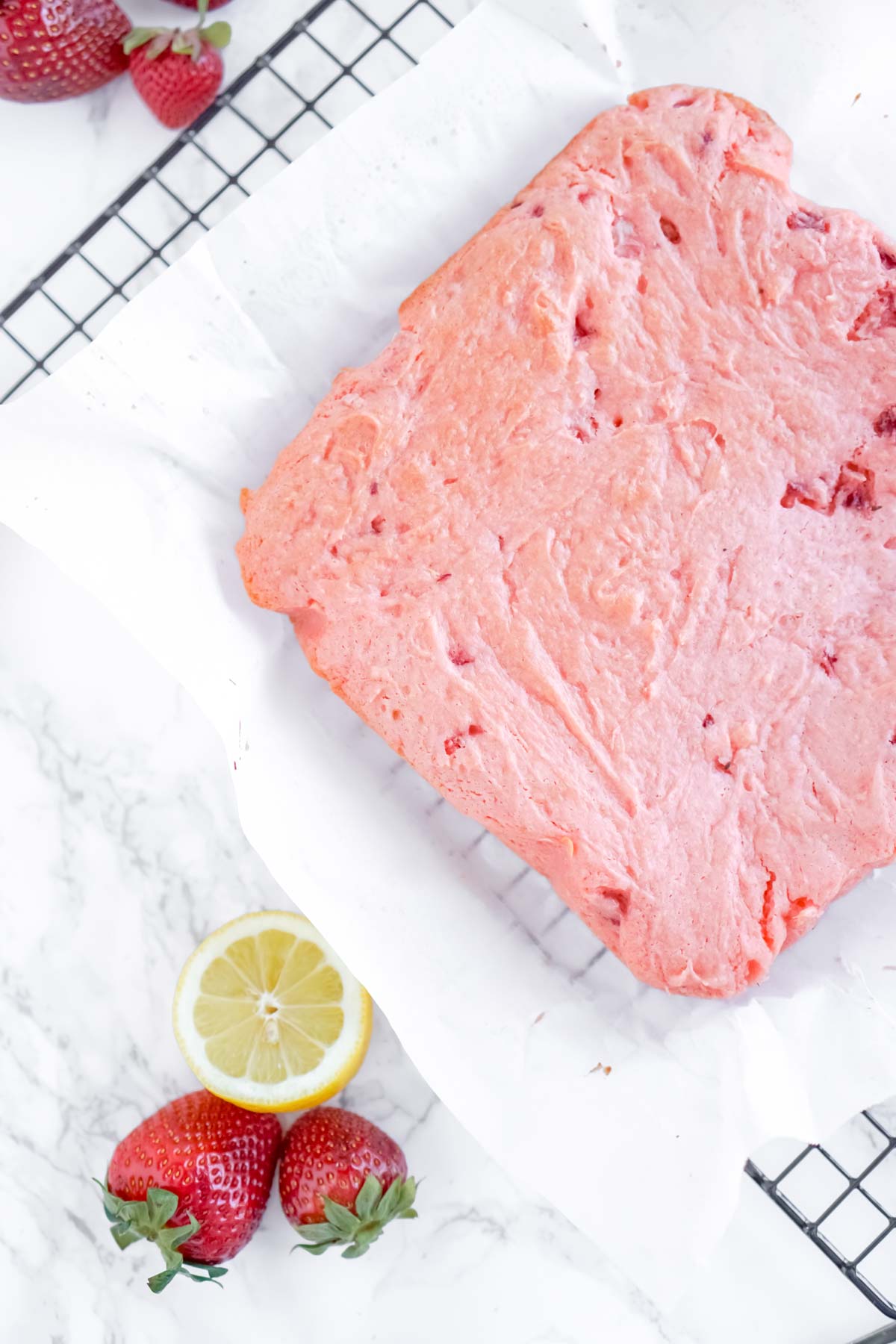 uncut strawberry brownies on a wire cooling rack