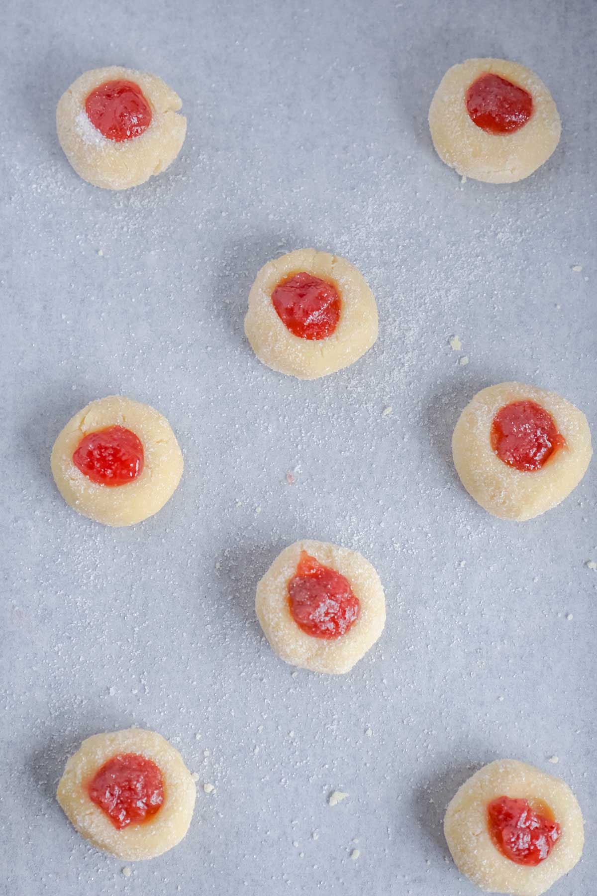 unbaked thumbprint cookies on a baking sheet