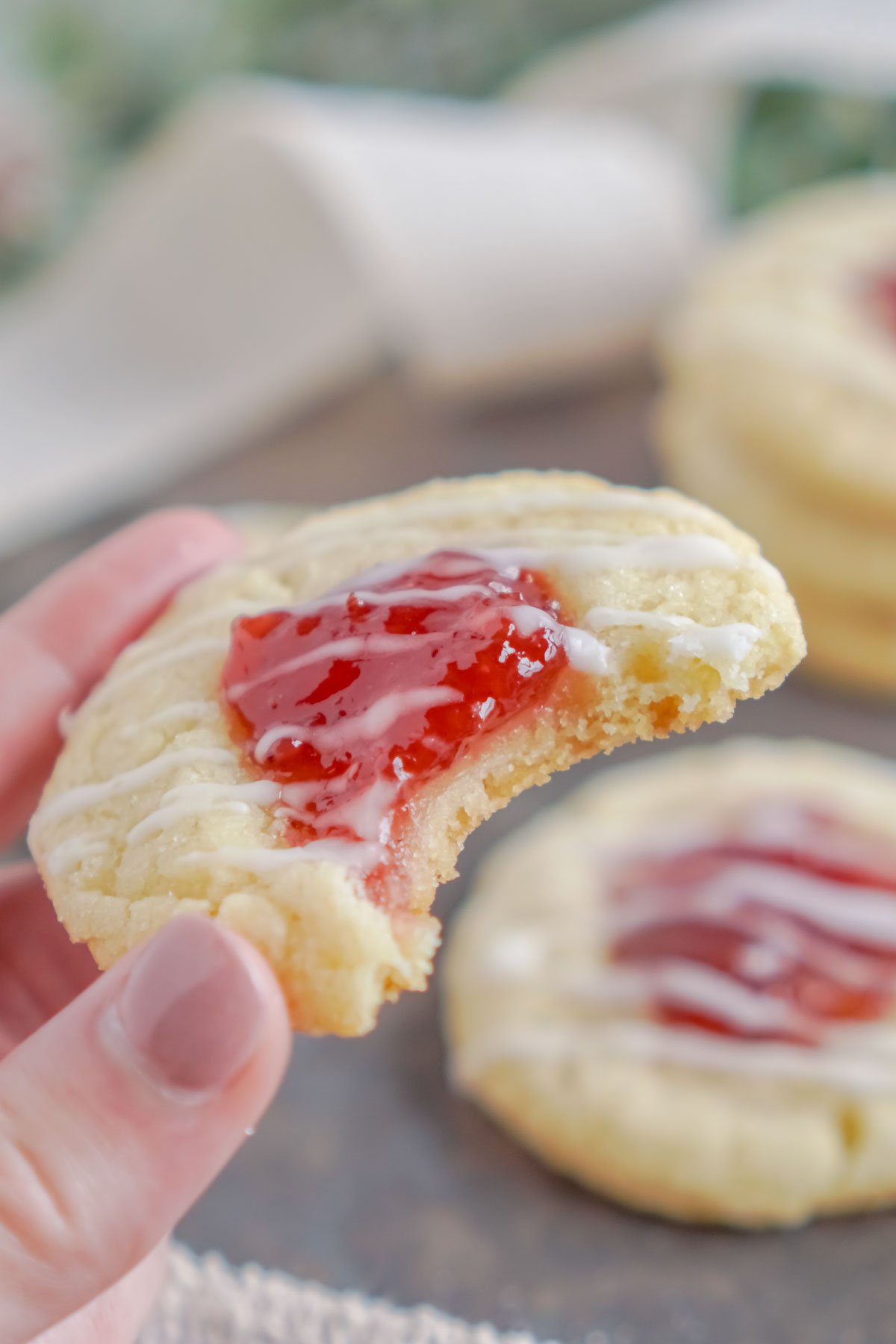 hand holding a strawberry thumbprint cookie