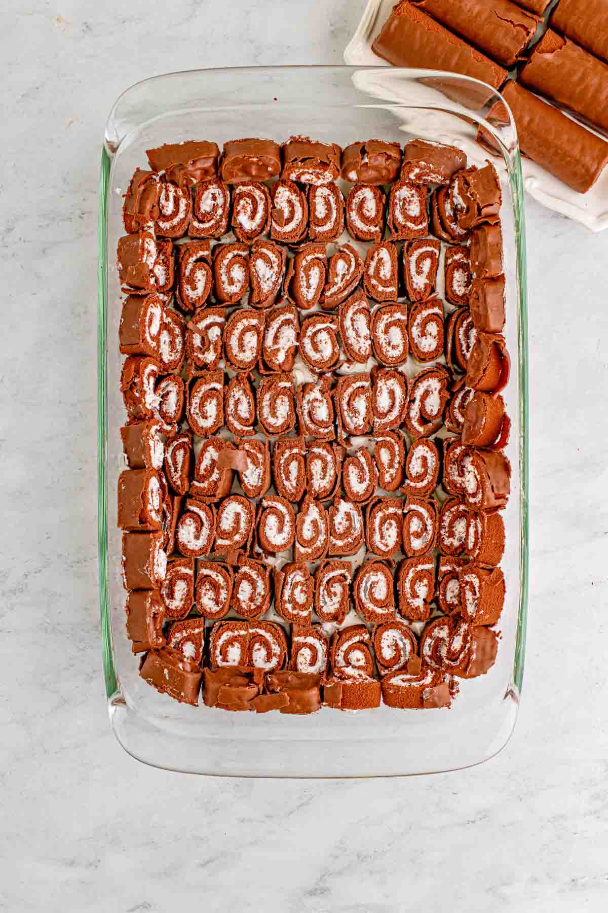 layer of swiss roll cakes in a baking dish