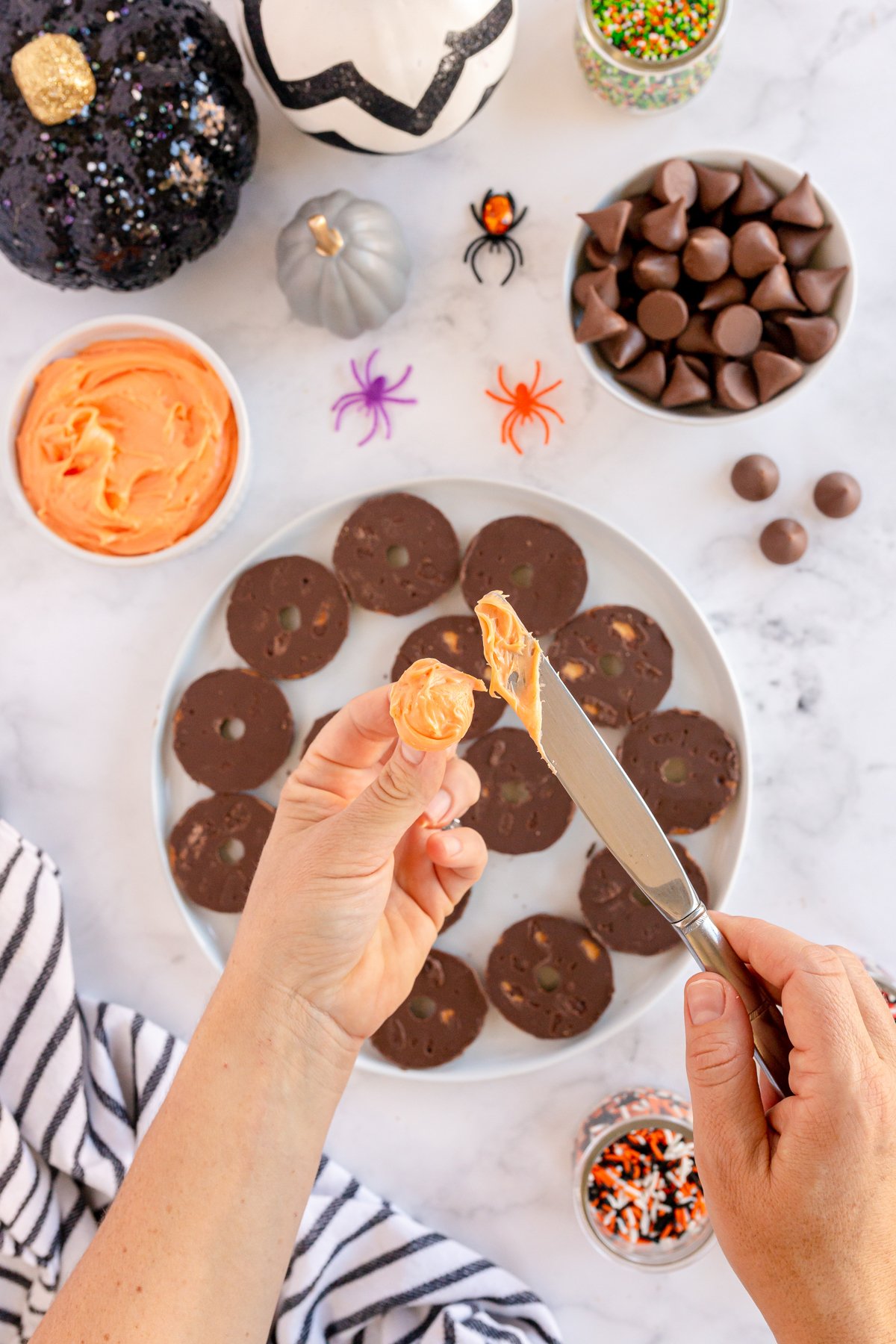 adding frosting to fudge stripe cookies