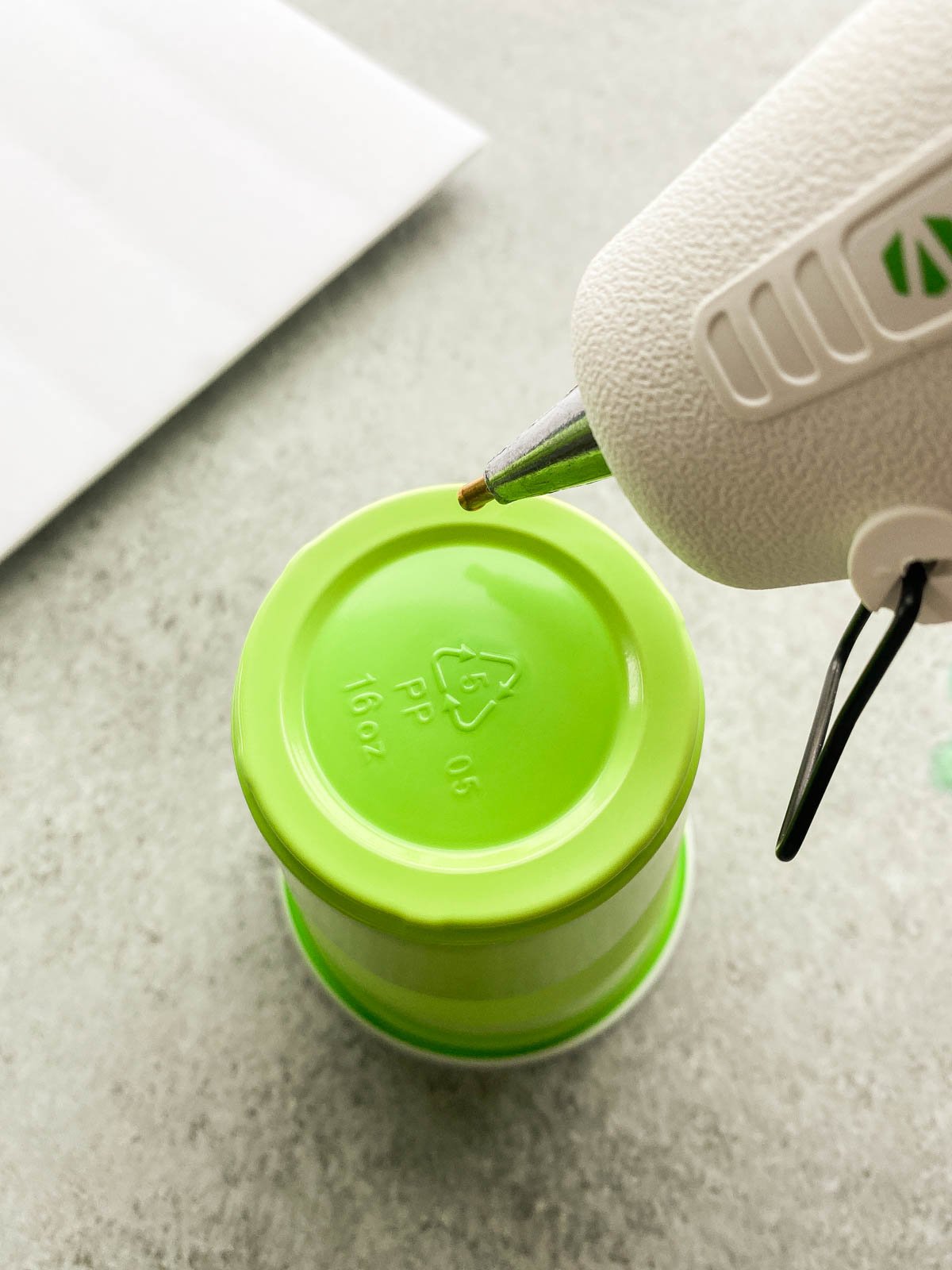 hot gluing the top of a plastic cup