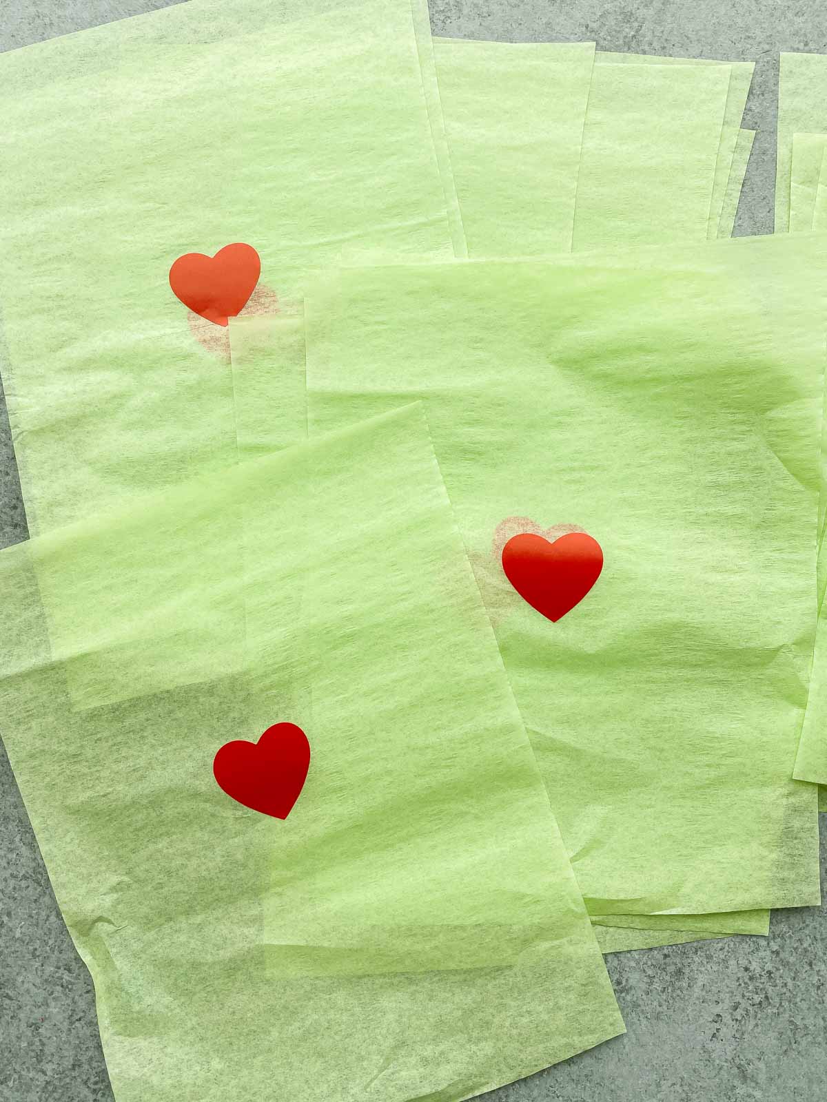 green tissue paper squares with heart stickers