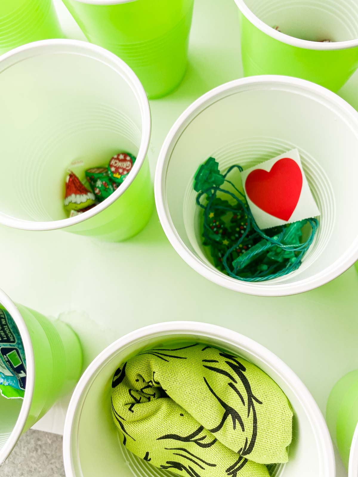 necklace and heart in a plastic green cup