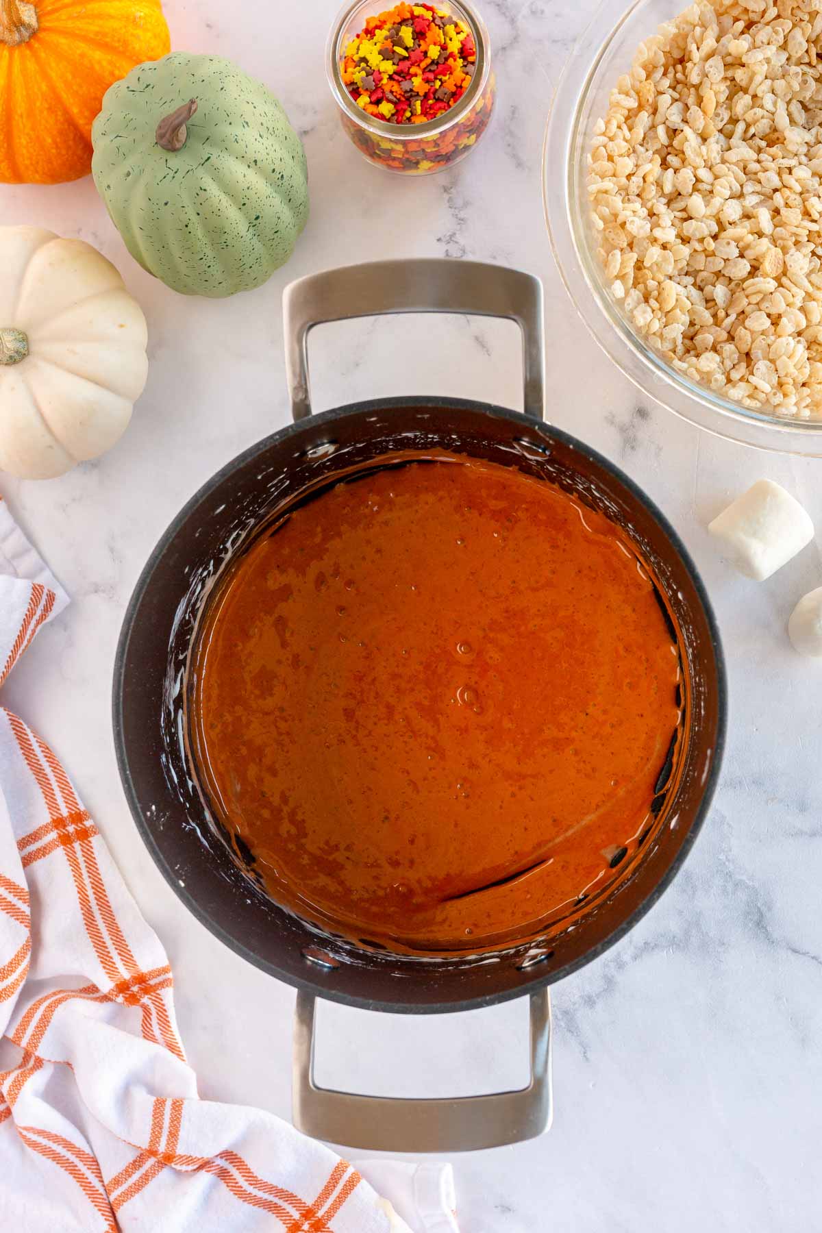 orange colored melted marshmallows in a metal pan