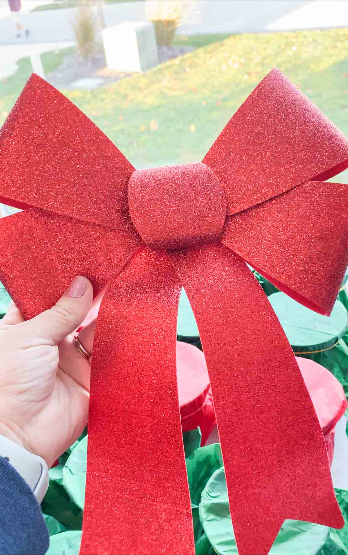 hand holding a large Christmas bow