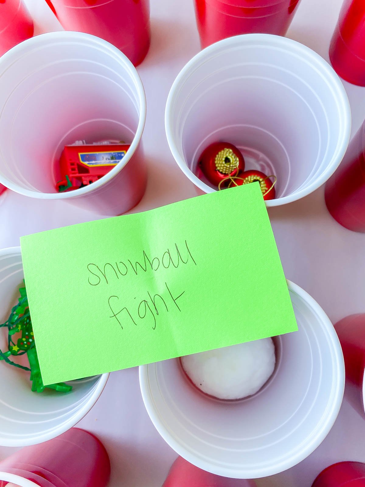 index card that says snowball fight on top of plastic cups