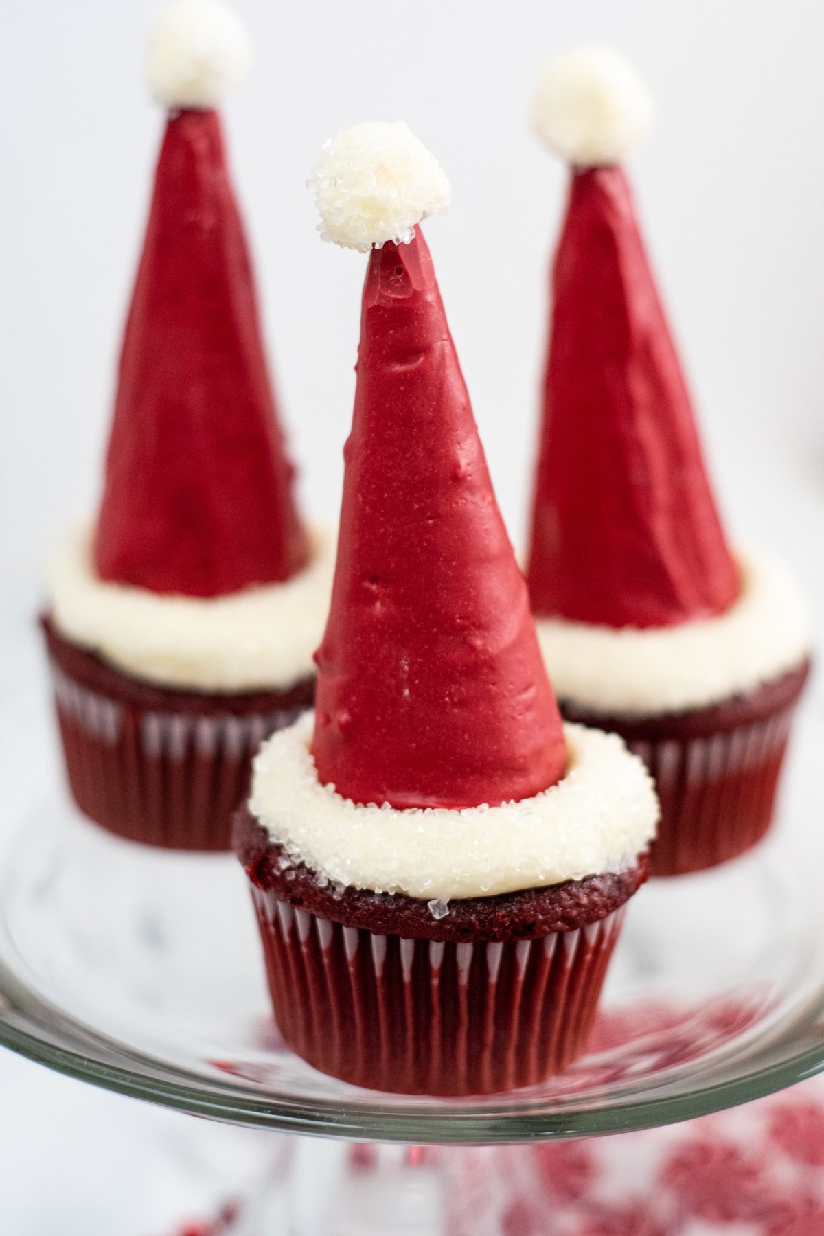Three Santa hat cupcakes on a cake stand