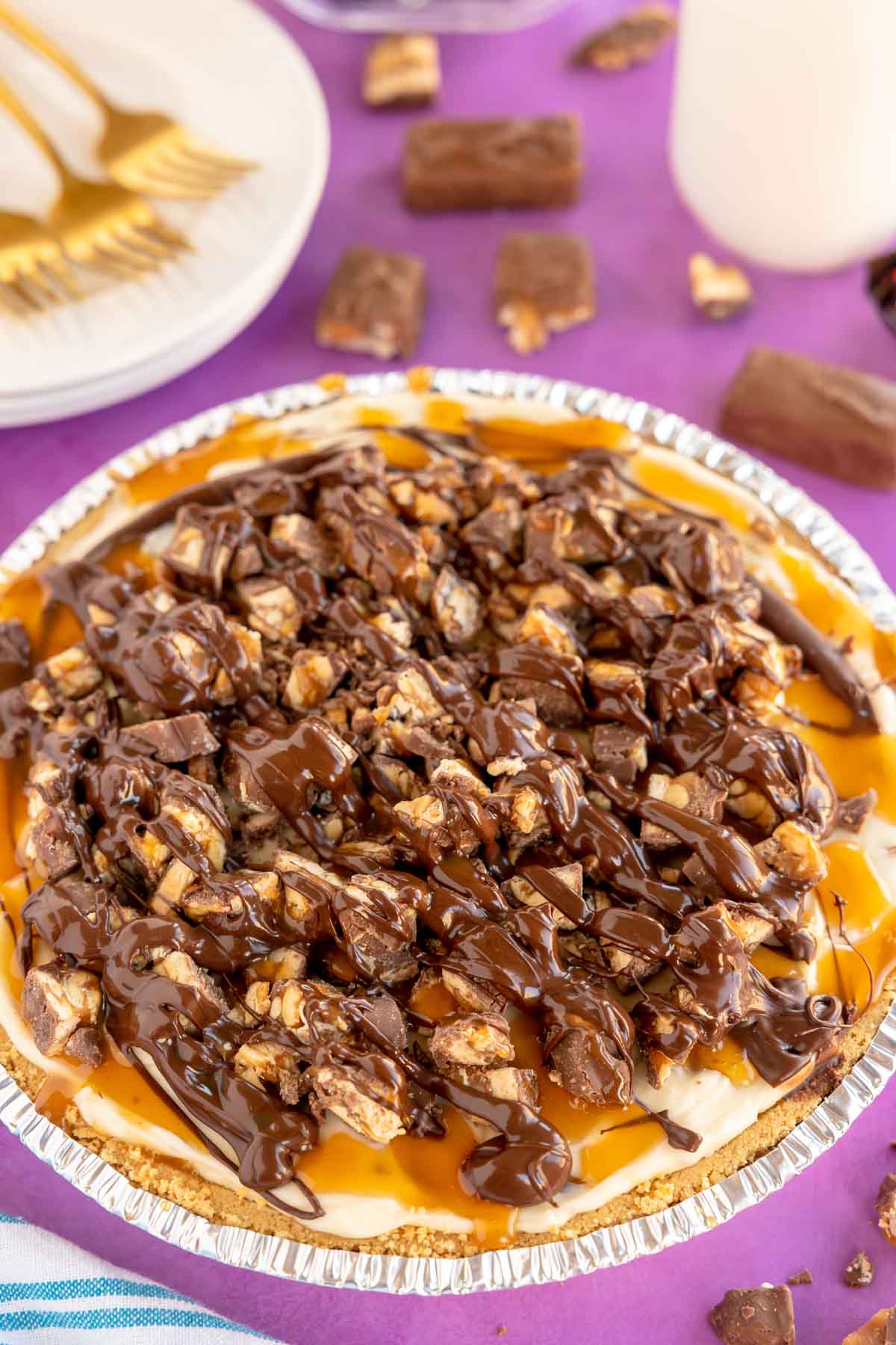 snickers pie topped with chocolate and caramel