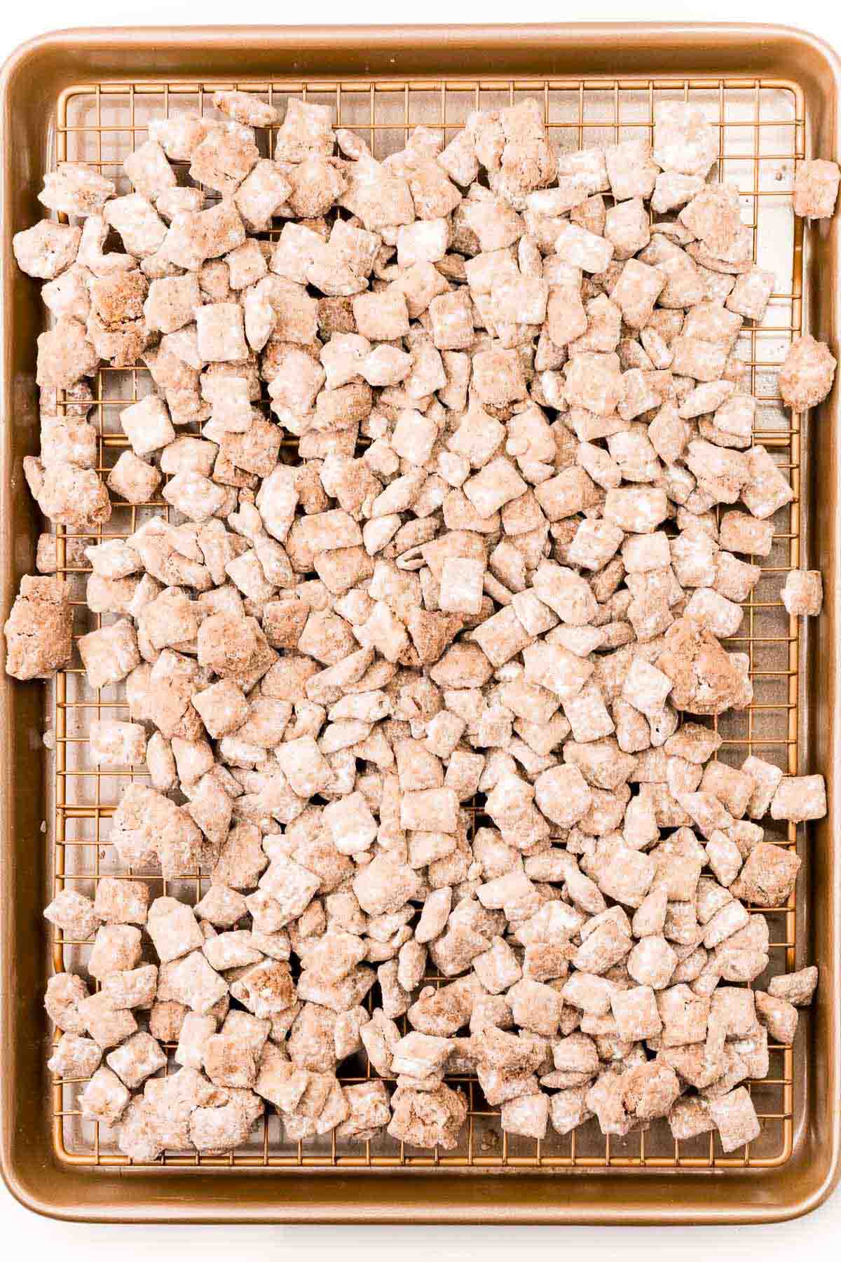 Christmas muddy buddies drying on a baking sheet