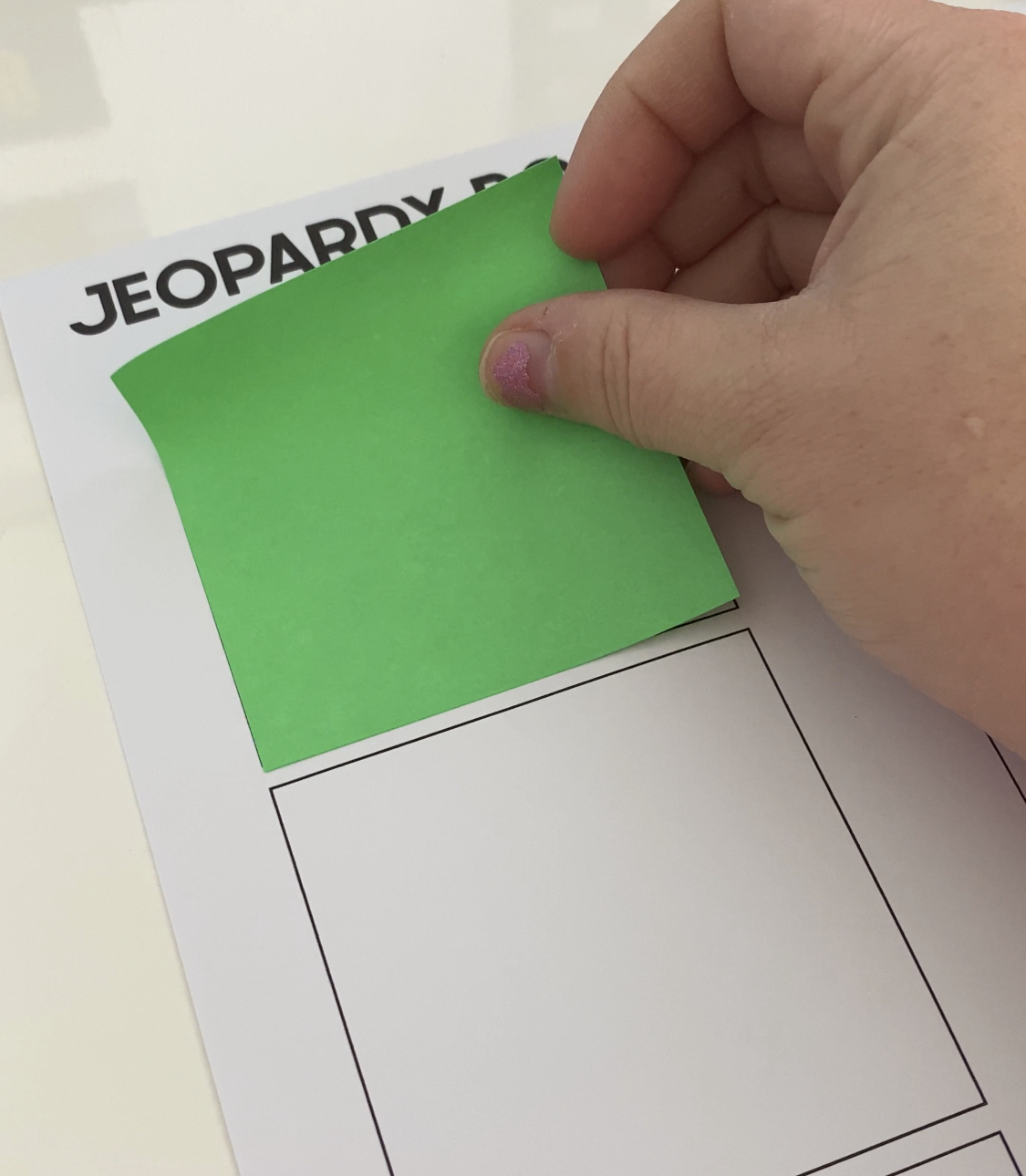 hand placing a post-it note on a piece of paper