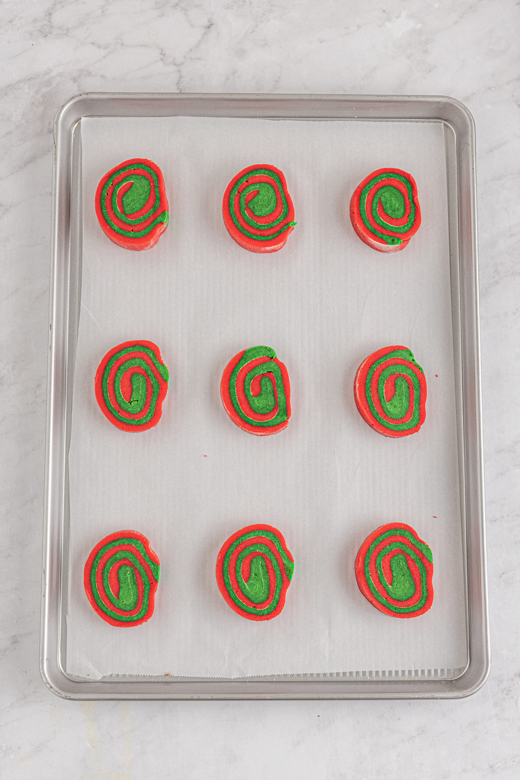 unbaked Christmas pinwheel cookies on a baking sheet