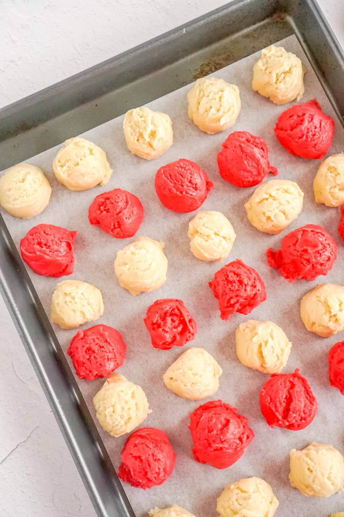 baking sheet with red and white sugar cookie dough rolls
