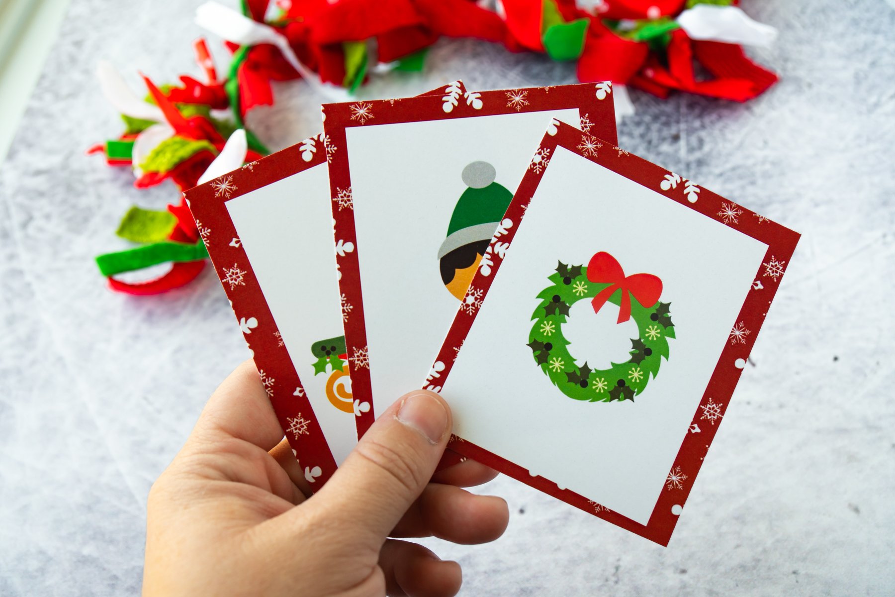 Hand holding Christmas matching cards in their hand