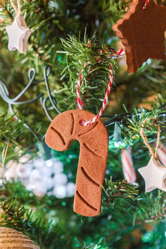 candy cane shaped cinnamon ornament hanging in a tree