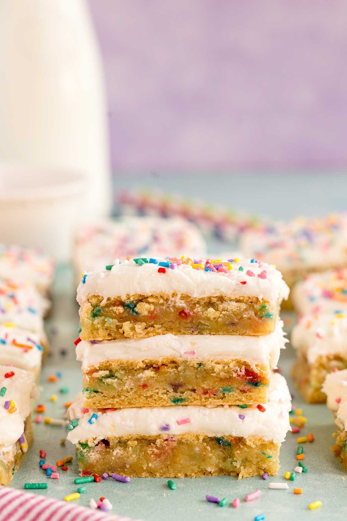 three stacked frosted sugar cookie bars with sprinkles