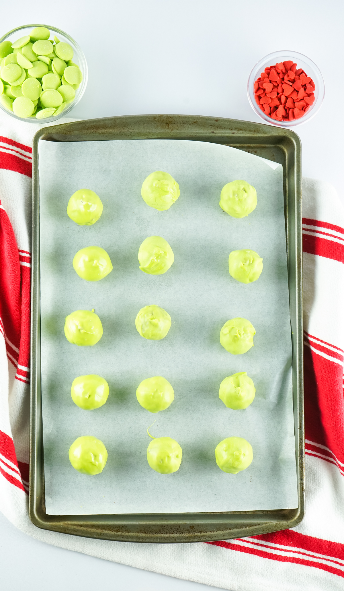 green Grinch Christmas balls on a baking sheet
