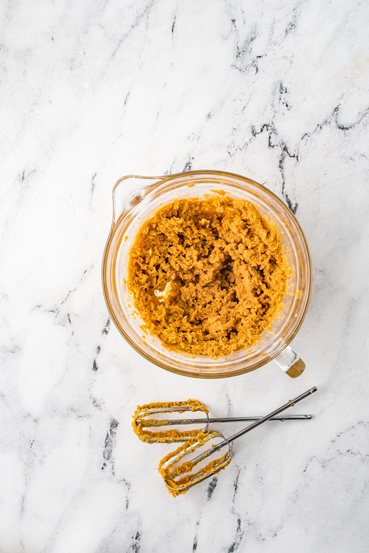 peanut butter and sugar creamed together in a glass bowl