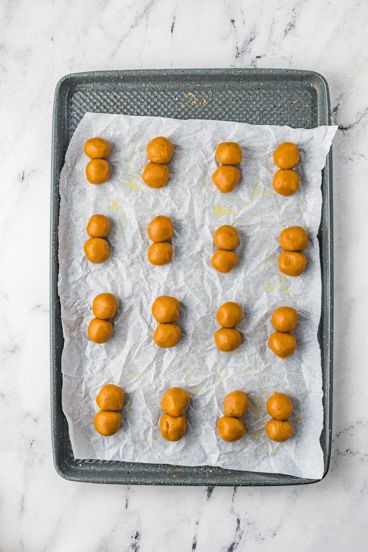 peanut butter balls on a parchment lined baking sheet