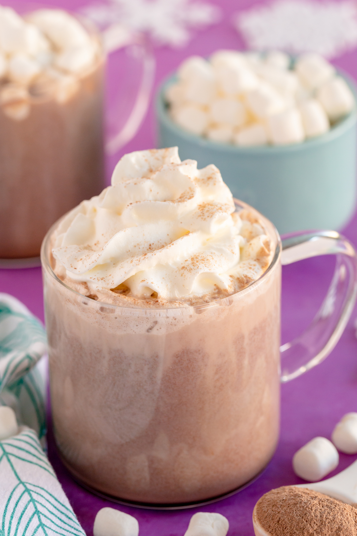 glass mug with hot chocolate topped with whipped cream