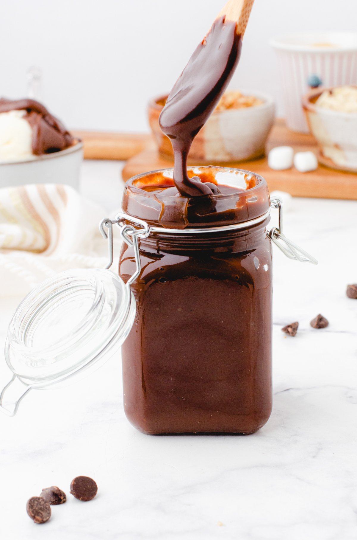 hot fudge being poured into a glass jar