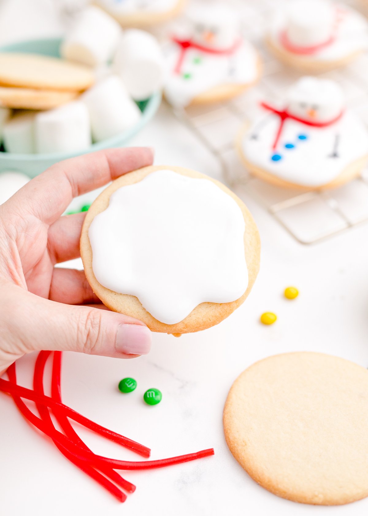 royal icing on a sugar cookie in someone's hand