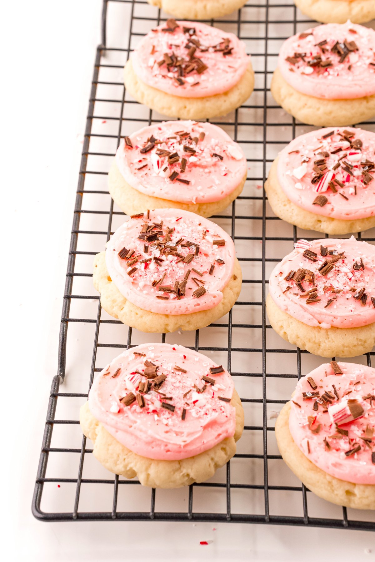 frosted peppermint sugar cookies on a cooling rack