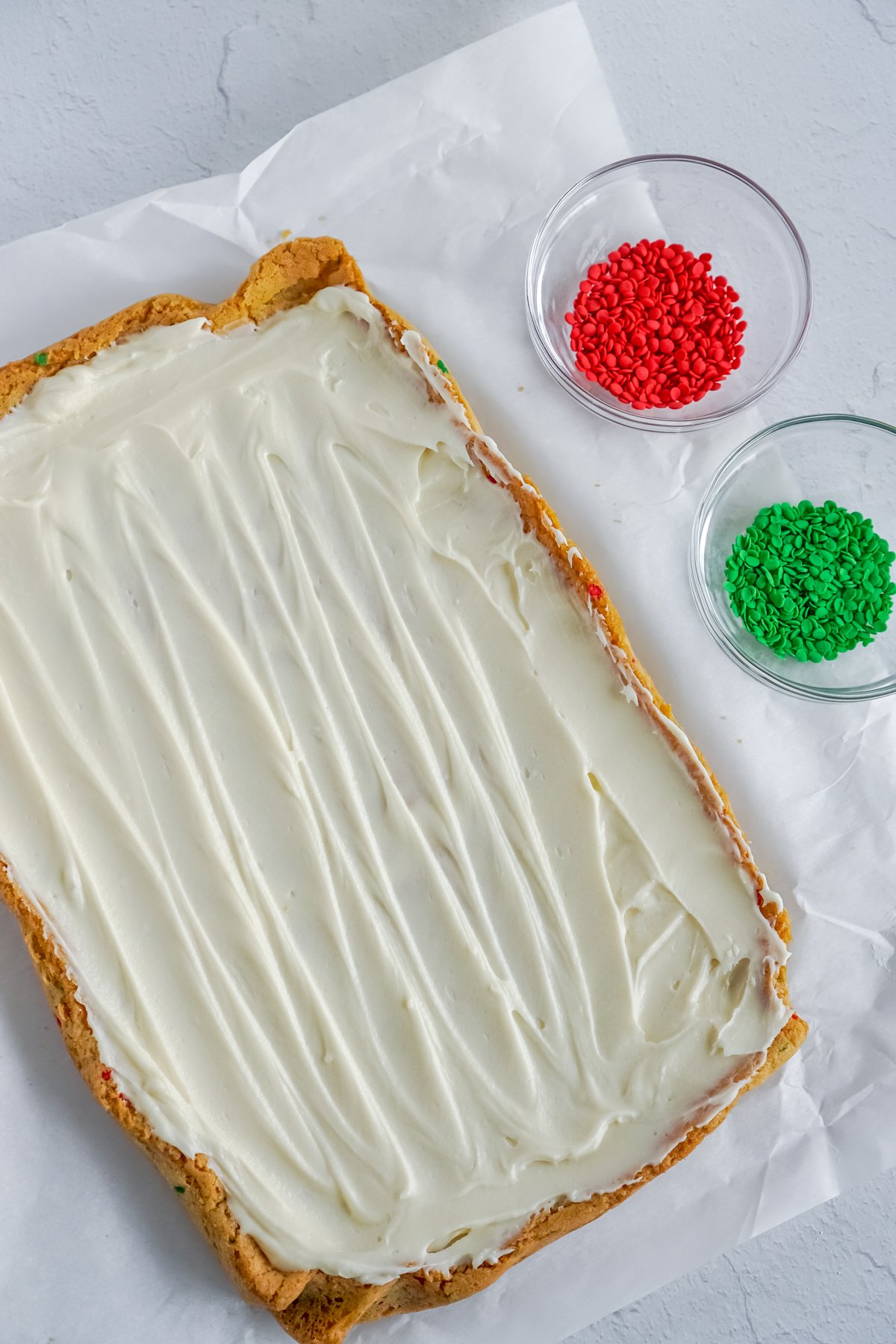 frosted sugar cookie bars on a piece of parchment paper