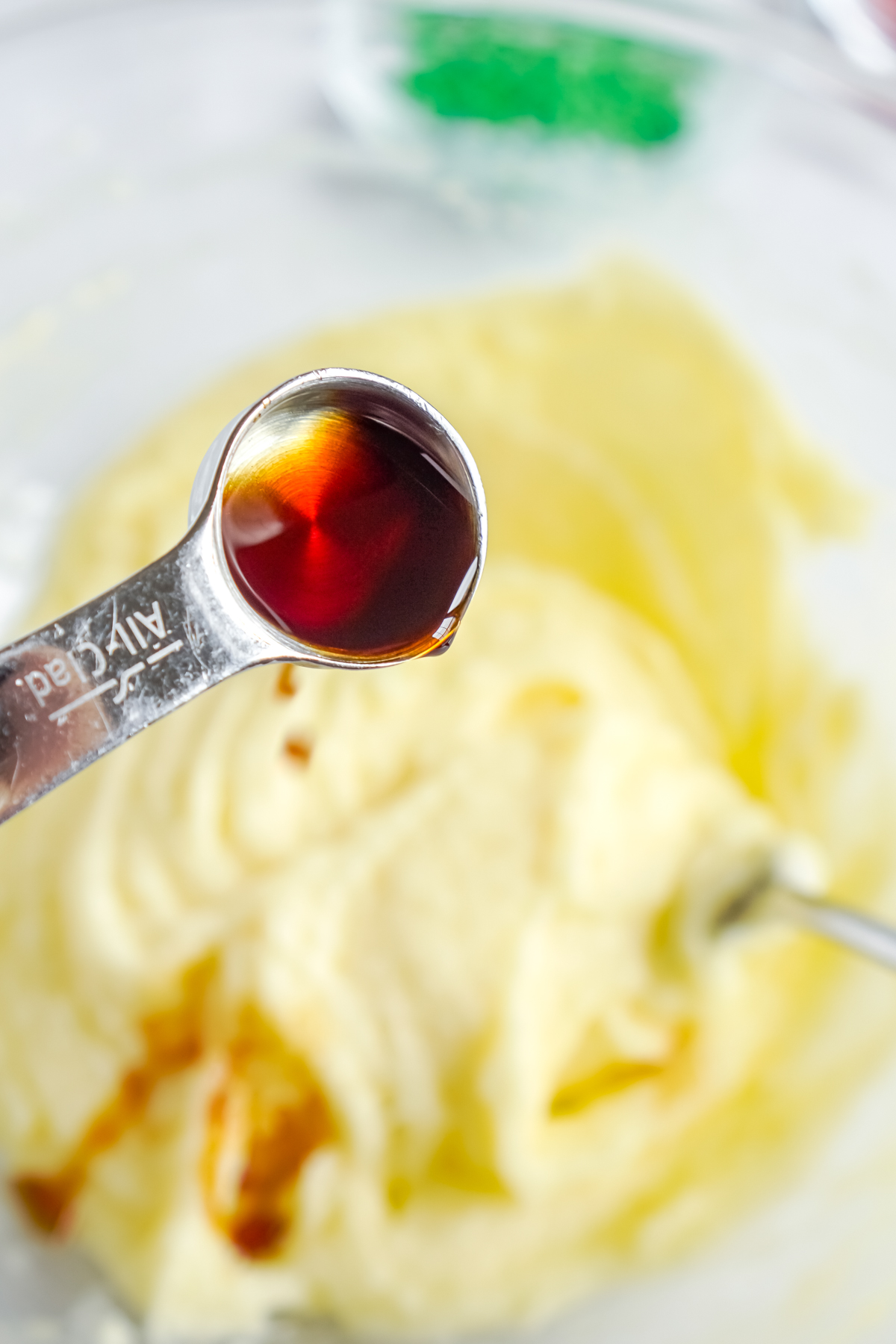 adding vanilla to a bowl of creamed butter and sugar
