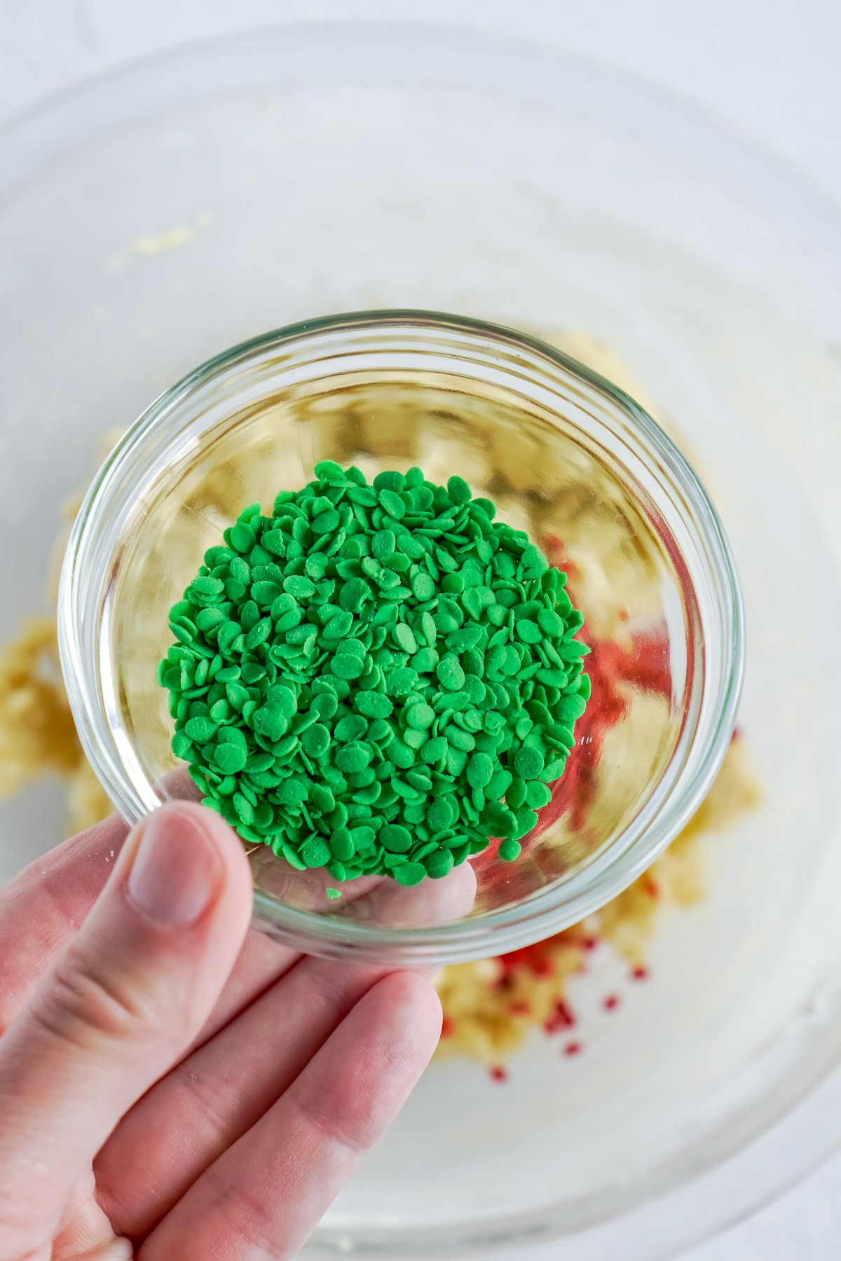 hand holding a small glass bowl with sprinkles