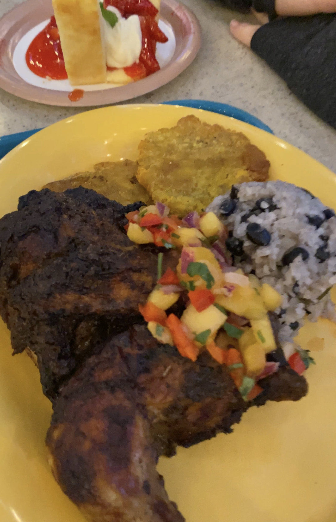 jerk chicken with salsa on a yellow plate