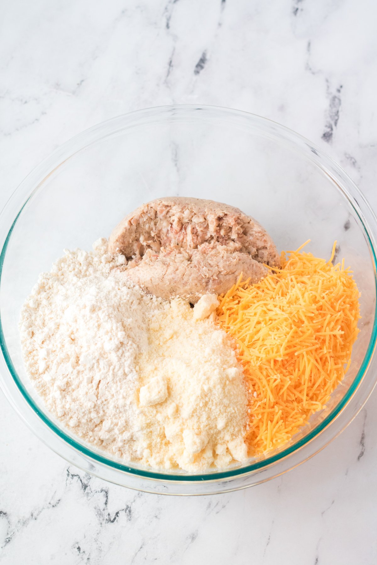 ingredients for sausage balls in a glass bowl